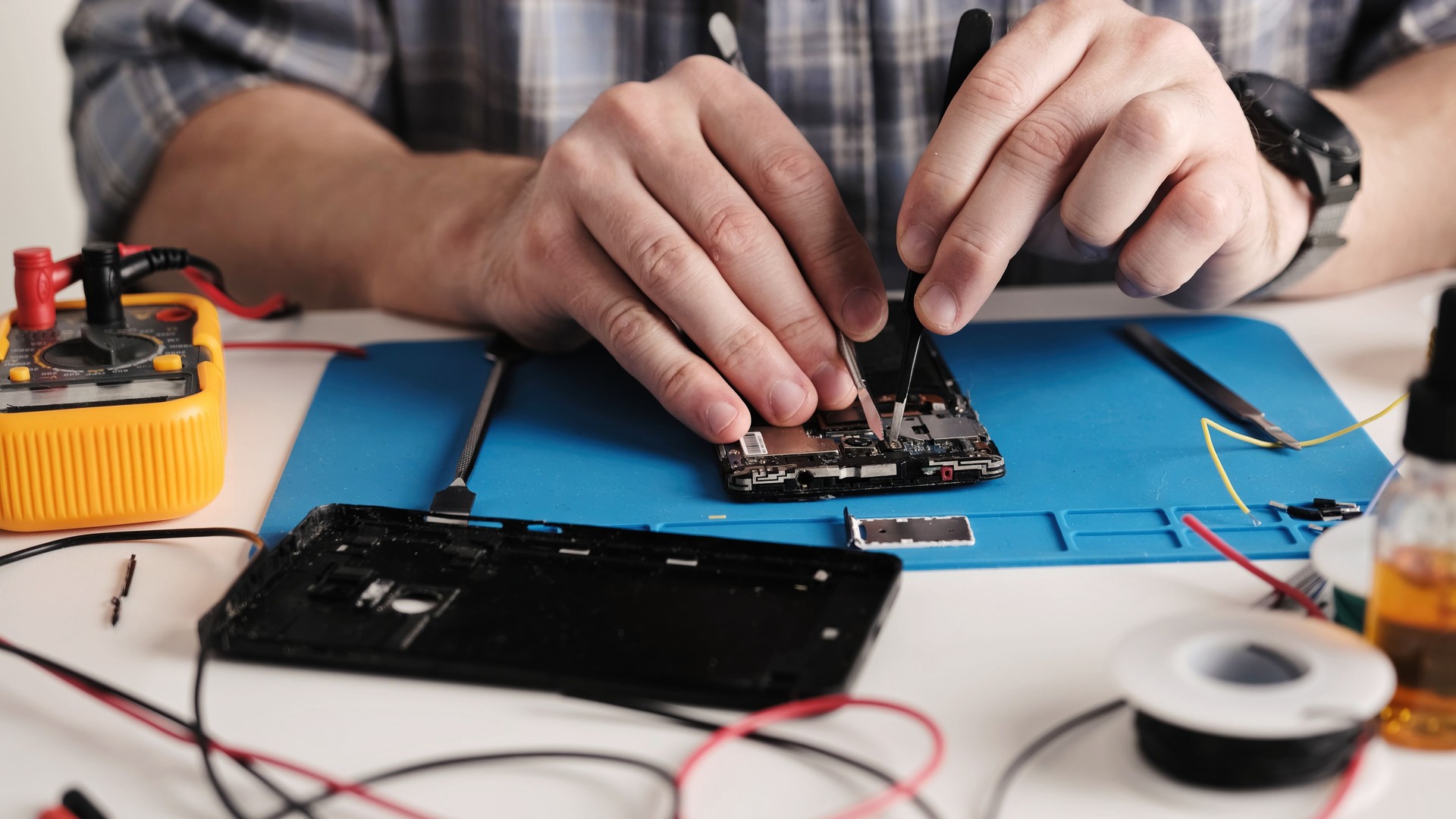 Service Technician Inspects Broken Phone Before Repair